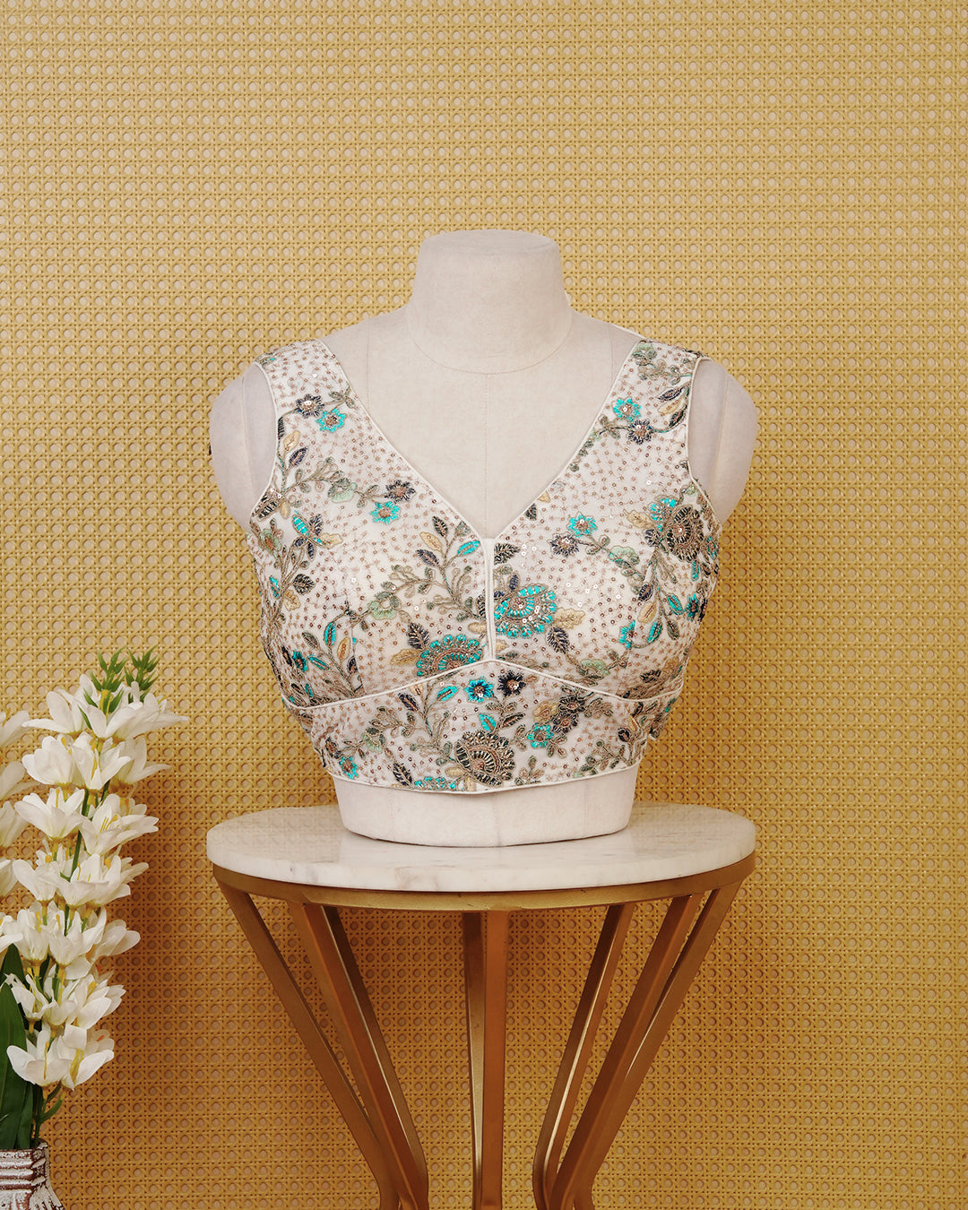 Ivory colour Embroidered Sleeveless Blouse Featuring A Stylish V-Neck, Intricate Floral Embroidery With Sequin Detailing, And A Comfortable Tailored Fit.