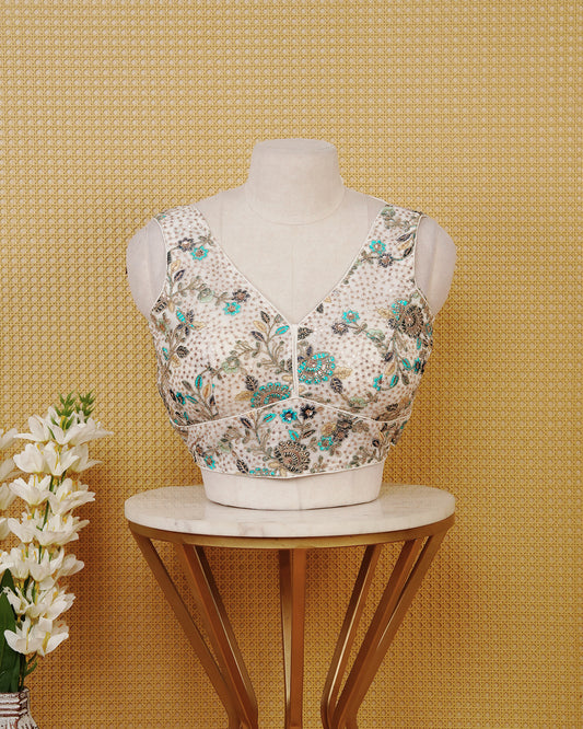 Ivory colour Embroidered Sleeveless Blouse Featuring A Stylish V-Neck, Intricate Floral Embroidery With Sequin Detailing, And A Comfortable Tailored Fit.
