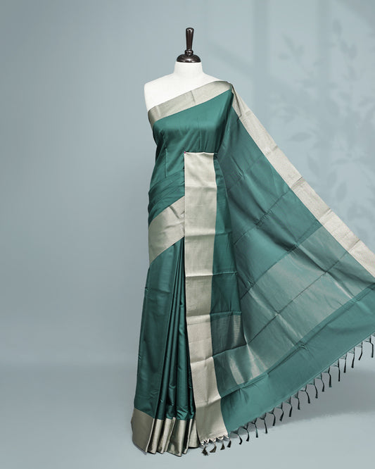 Green colour saree featuring a plain body, complemented by a Bavanchi border and contrast pallu, paired with a matching blouse piece.