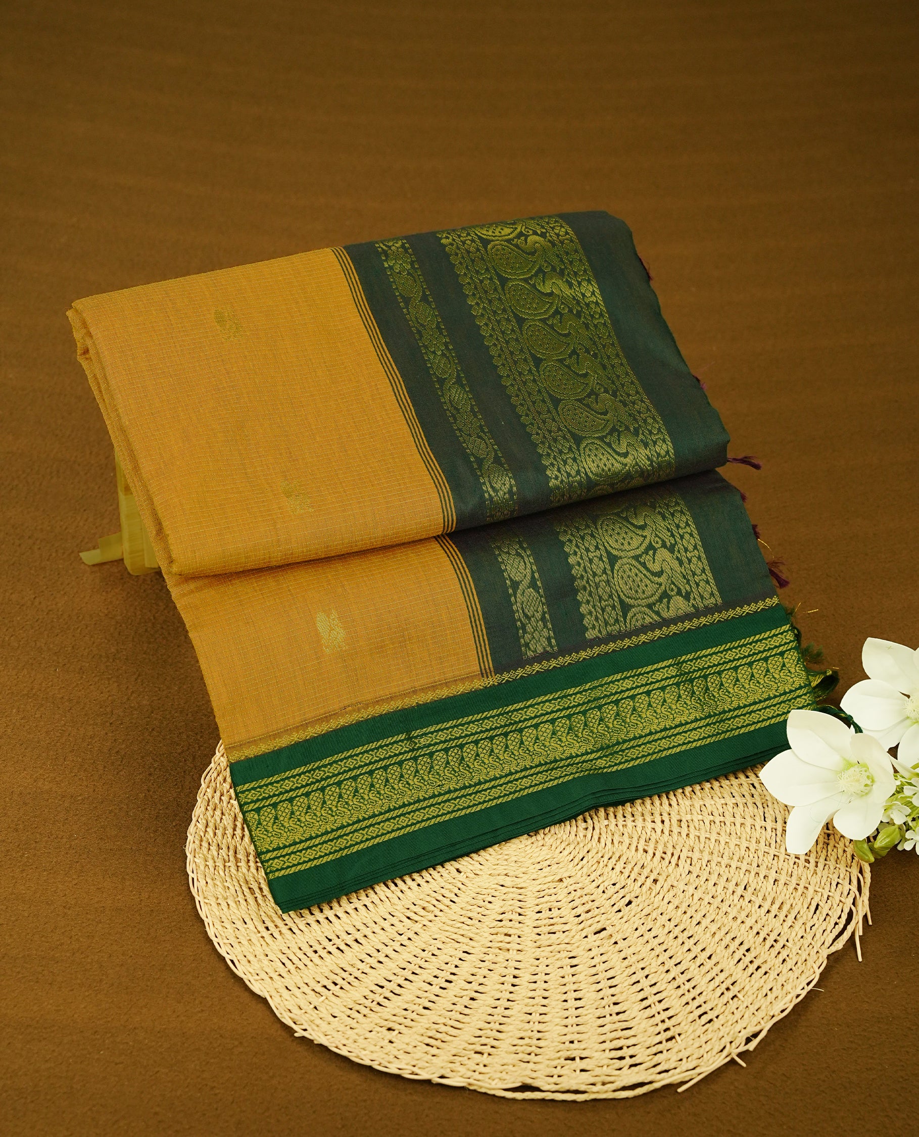 Turmeric Yellow colour kalyani cotton saree featuring gold zari Small checks & Zari Motifs pattern on body, complemented by Dark Green colour with Antique zari border, paired with matching blouse piece