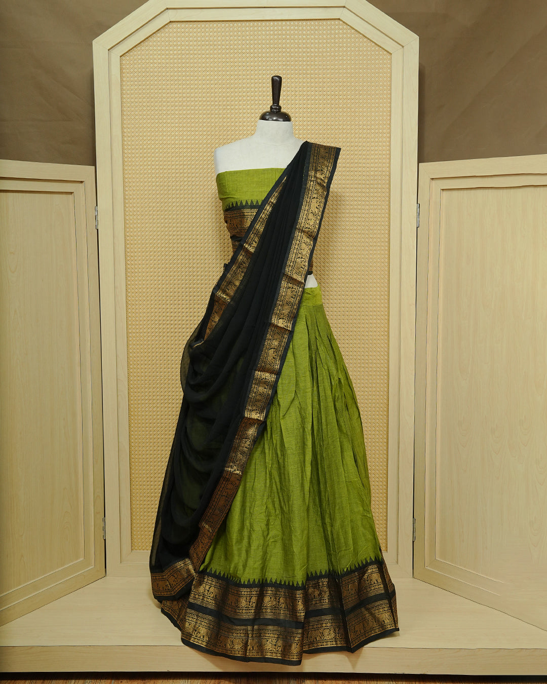 Green colour Chettinad Semi Stitched dhavani set Featuring contrast Black with Gold zari border on skirt, Contrast Blouse & matching dupatta.