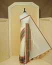 Cream colour Mul cotton saree featuring Elegant Plain body, complemented by contrast Red, Black & gold zari border & Tassels.