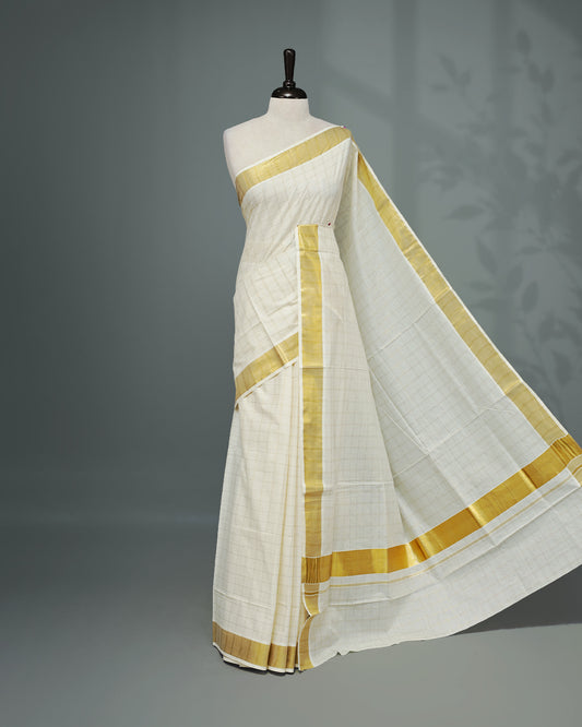 Cream colour Kerala saree Featuring Gold zari Checks on the body, complemented by a classic gold zari border, matching blouse piece.