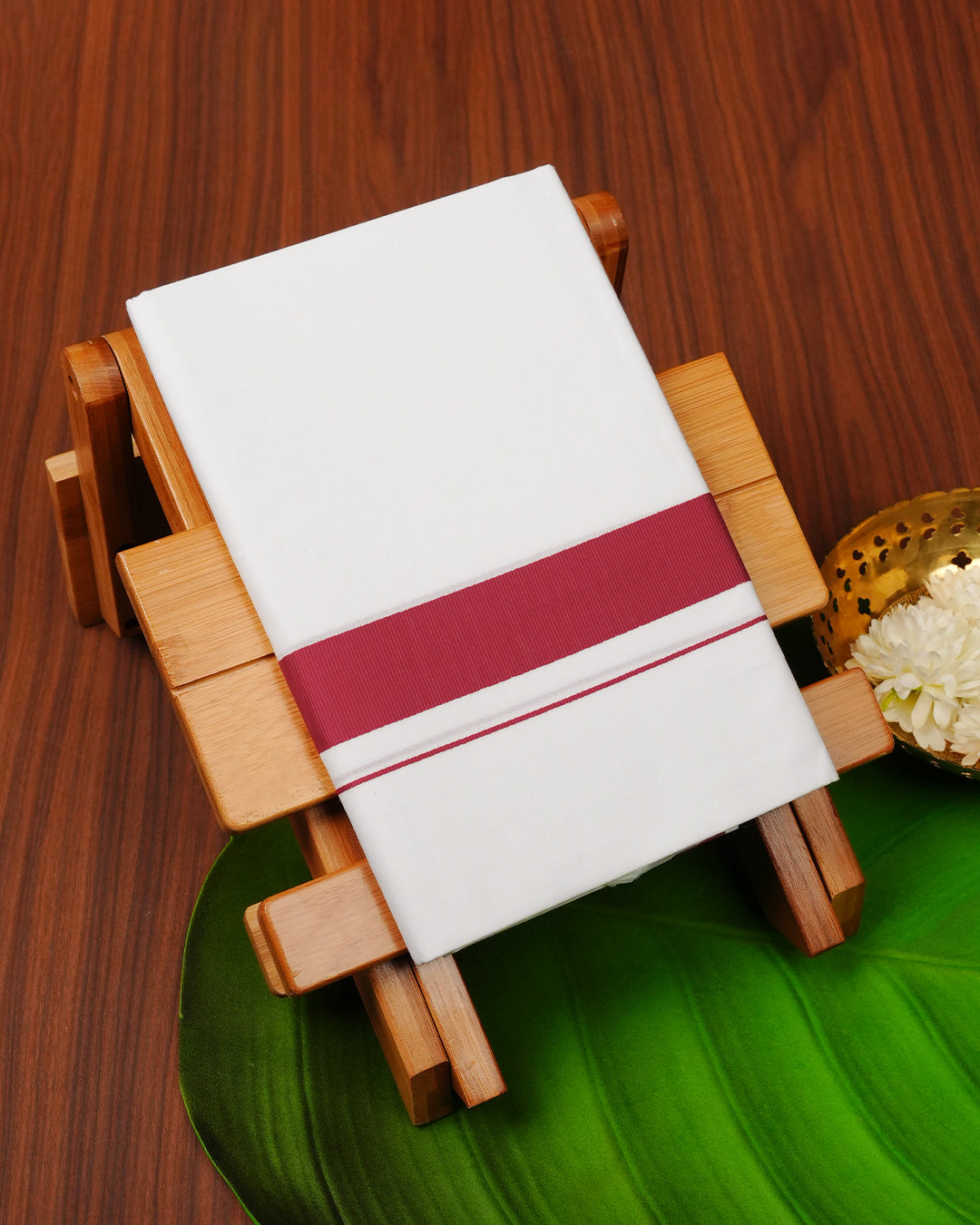 White colour cotton single dhoti featuring Rani Pink border.