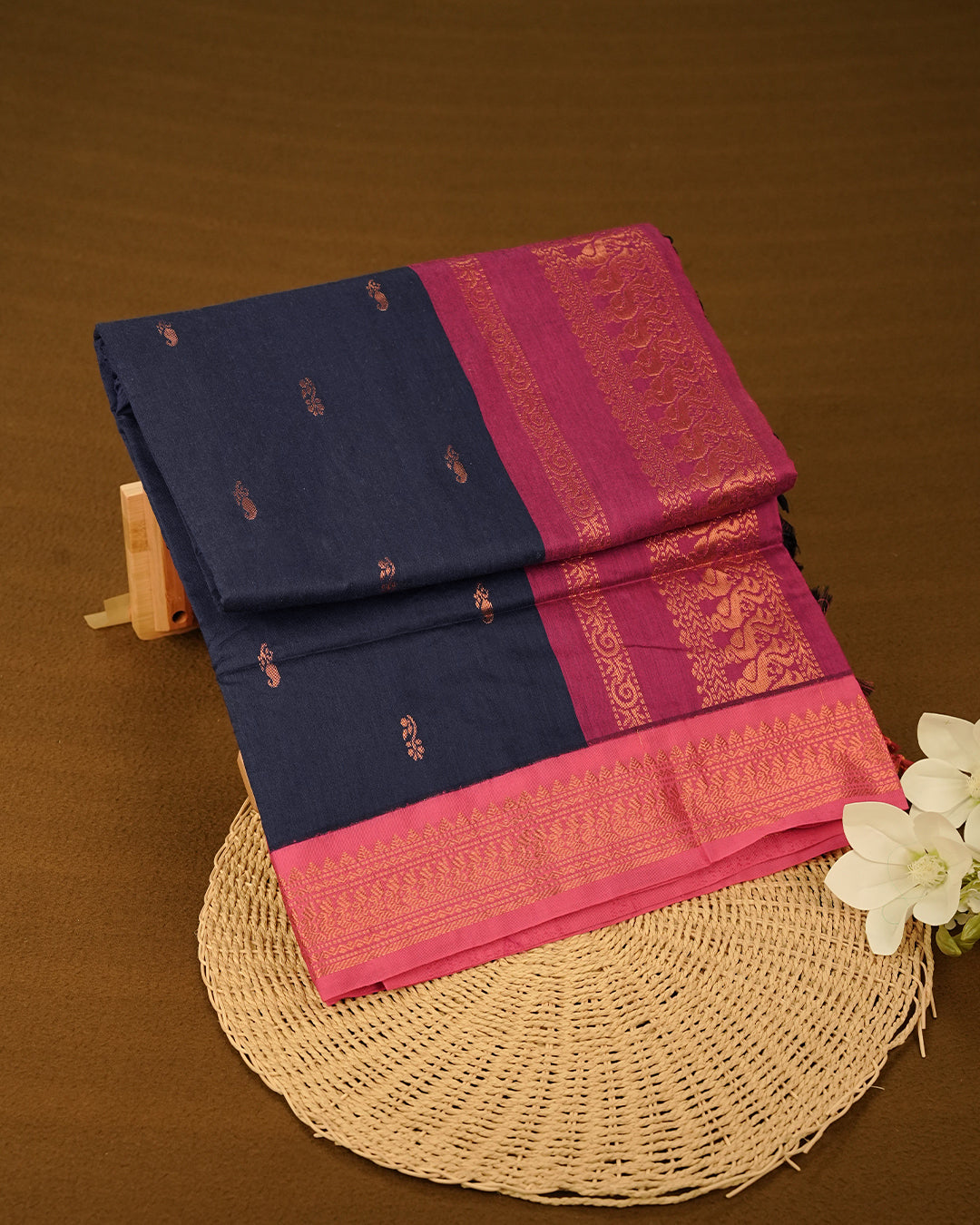 Navy Blue colour Kalyani cotton saree featuring delicate antique zari floral butta motifs on the body, complemented by a Magenta contrast pallu with a rich antique zari peacock border, paired with a matching Magenta blouse piece