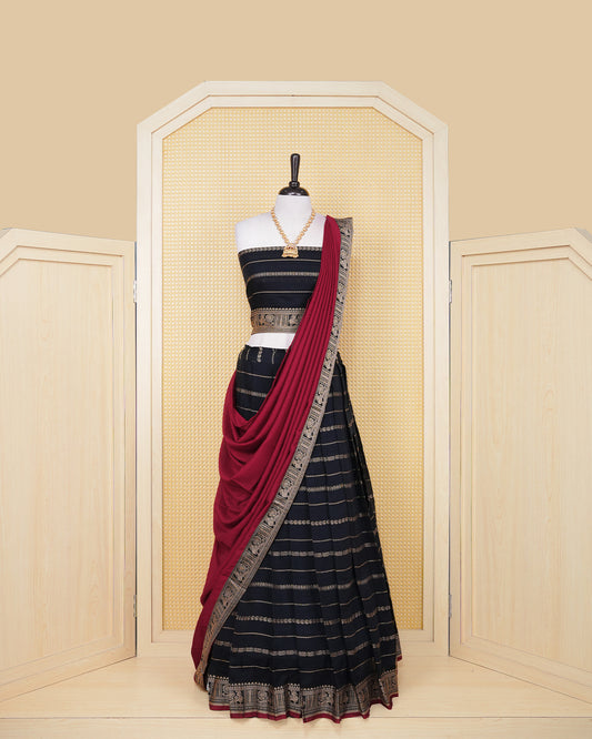 Black colour Chettinad Semi Stitched dhavani set Featuring black with light Gold zari strips on skirt, matching Blouse & Contrast dupatta.