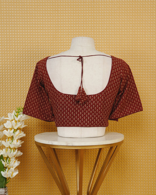 Maroon Colour Printed Blouse Featuring An All Over Small Teardrop Motif Pattern, Enhanced With A Round Neckline, Front Button Closure, And Short Sleeves.