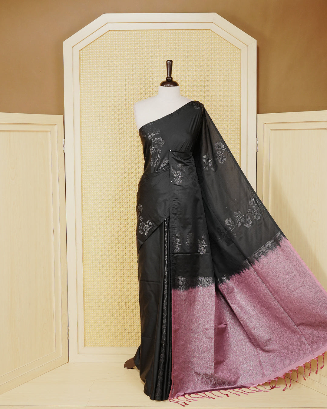 Black colour soft silk saree featuring antique zari motifs on body with contrast dusty rose colour pallu & paired with matching blouse piece.