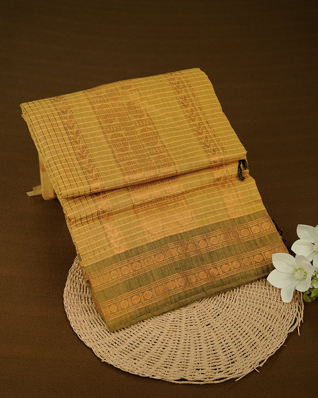 Mustard colour kalyani cotton saree featuring gold zari check pattern on body, complemented by Olive colour with Antique zari border, paired with matching blouse piece