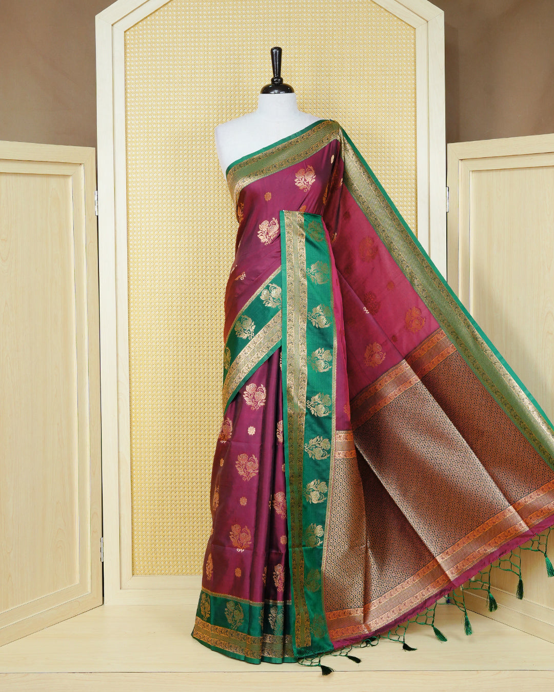 Maroon colour Mulberry silk saree featuring gold floral zari patterns on body, paired with contrast green colour with traditional border, comes with matching blouse piece.
