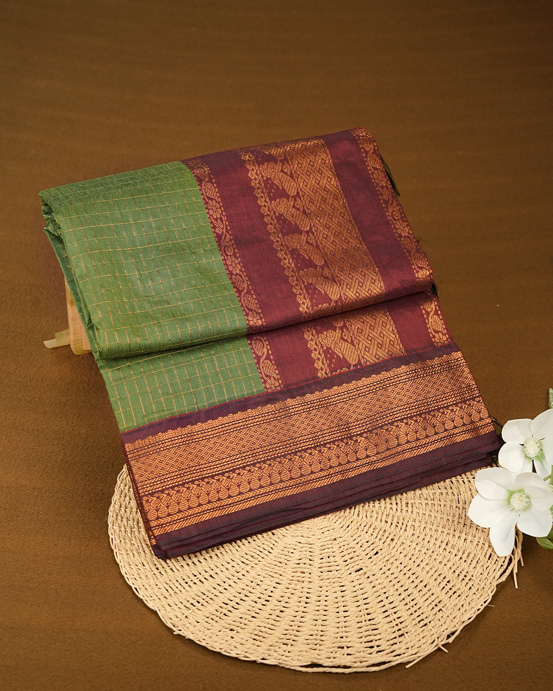 Green colour kalyani cotton saree featuring gold zari check pattern on body, complemented by Maroon colour with Antique zari border, paired with matching blouse piece