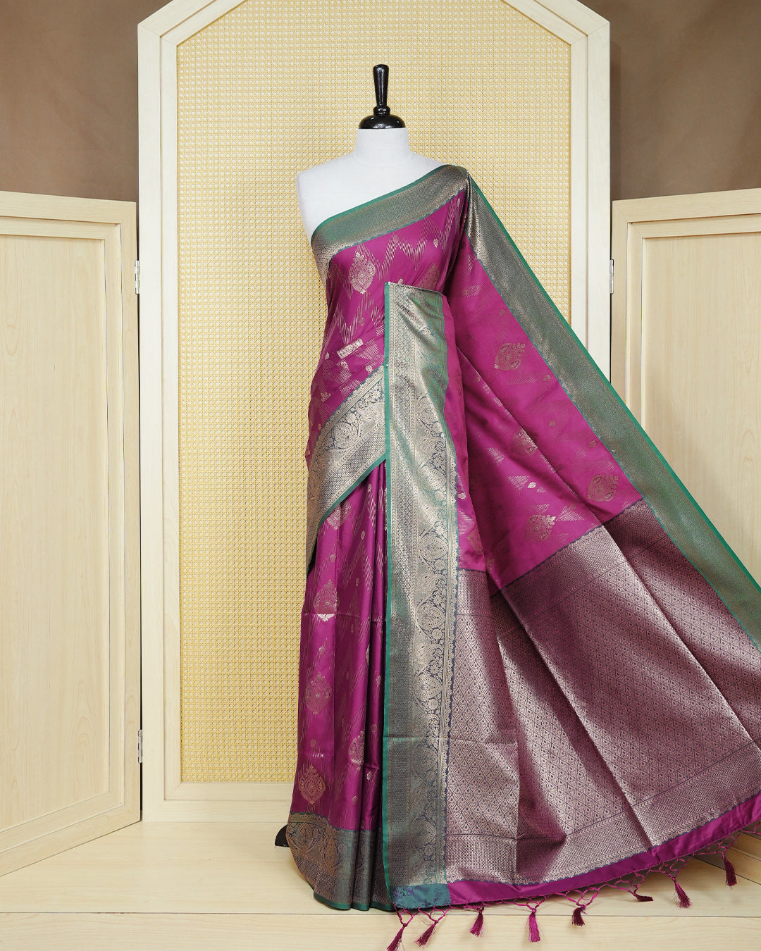 Magenta colour Mulberry silk saree featuring gold floral zari patterns on body, paired with contrast green colour with traditional border, comes with matching blouse piece.