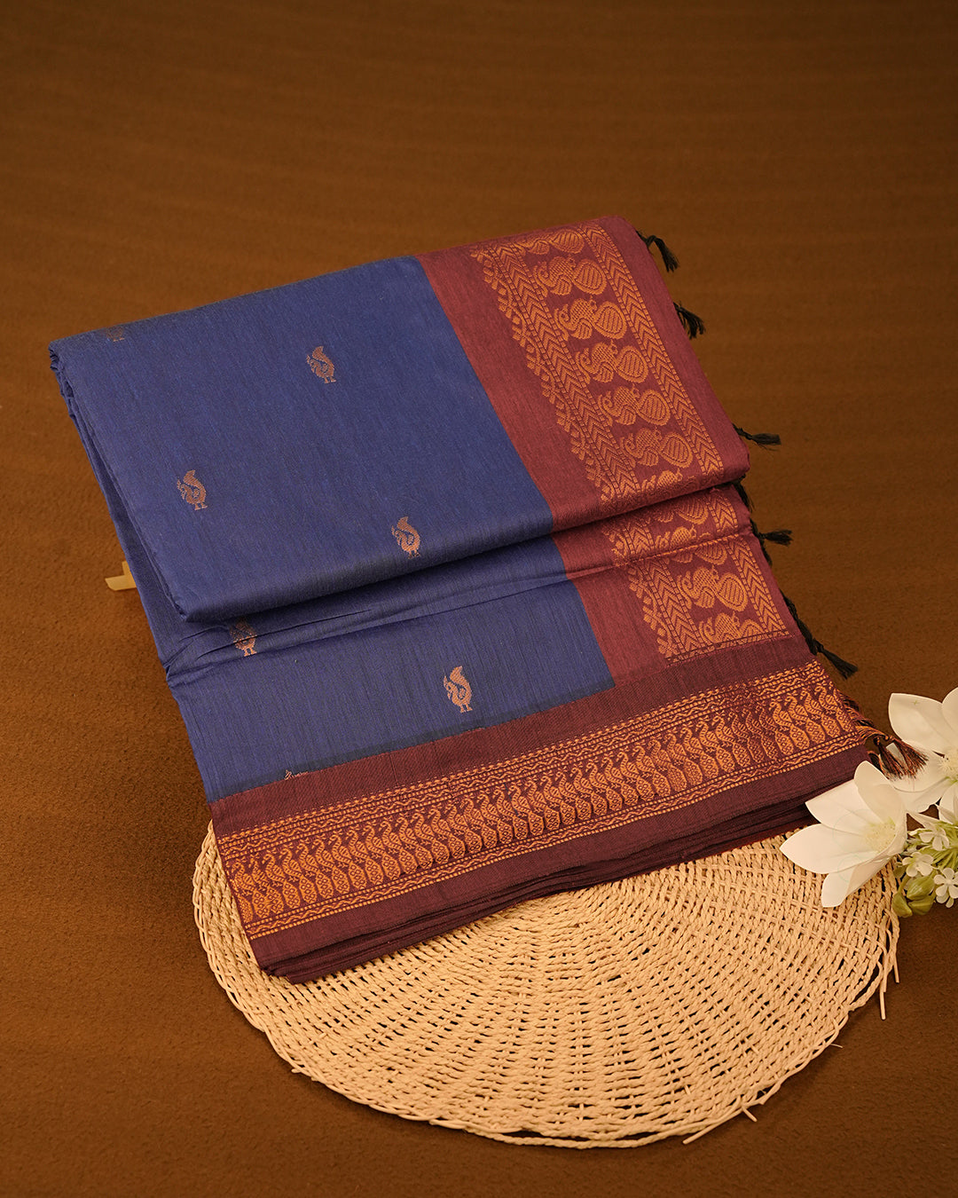 Navy Blue Colour Kalyani cotton saree featuring elegant antique zari peacock butta motifs on the body, complemented by a Maroon contrast pallu with a rich antique zari border, paired with a matching blouse piece