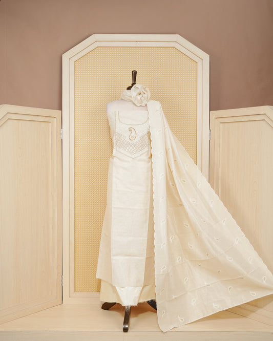 Cream colour tissue salwar material featuring elegant floral embroidery pattern adorned with Mirror and beadswork on Top, paired with matching bottom and elegant dupatta.