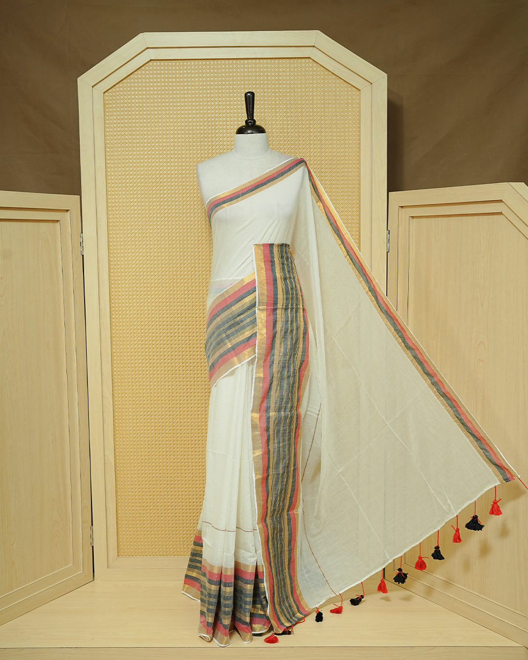 Off-White Mul Cotton Saree featuring a plain body with a multicolour striped zari border in shades of Red, Black, and gold & red and black tassels