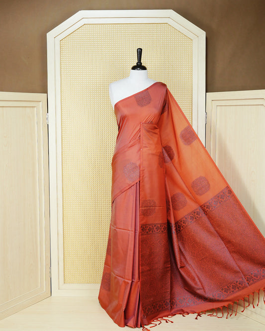 Brick orange colour soft silk saree featuring antique zari motifs on body with contrast self colour pallu & paired with matching blouse piece.