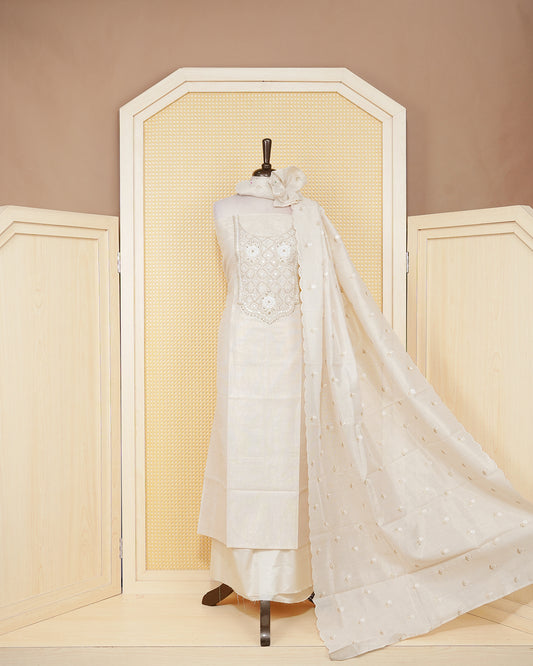 Cream colour tissue salwar material featuring elegant floral embroidery pattern adorned with Mirror and beadswork on Top, paired with matching bottom and elegant dupatta.