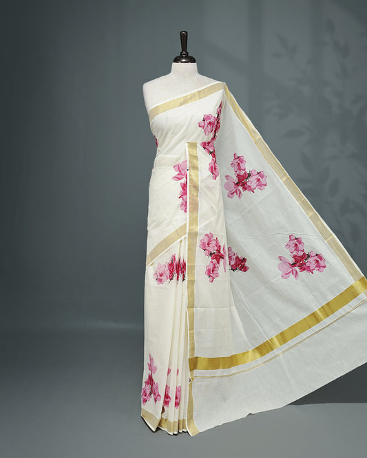 Cream colour Cotton kerala saree featuring Magenta colour floral Print on the body, complemented by a gold zari Border, paired with a matching blouse piece.