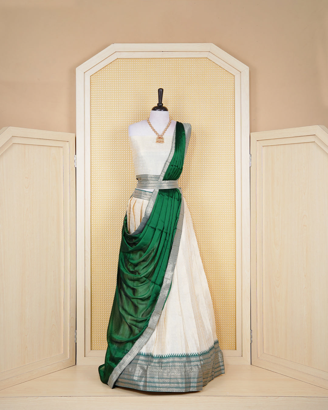 Cream colour Tissue Semi stitched dhavani set featuring Gold zari check pattern on body ,contrast Green colour with gold zari bordered skirt, paired with matching blouse piece & dupatta.