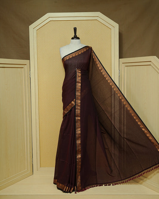 Chocolate brown colour Mul cotton saree featuring an elegant plain body, complemented by self colour with Gold zari border & tassels.