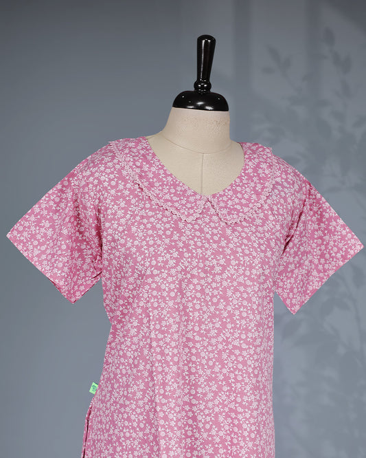 Blush pink colour nighty featuring white floral prints ob body, a U Shaped neckline with lace-trimmed Peter Pan collar, short sleeves, and a ruffled Mid-length fit
