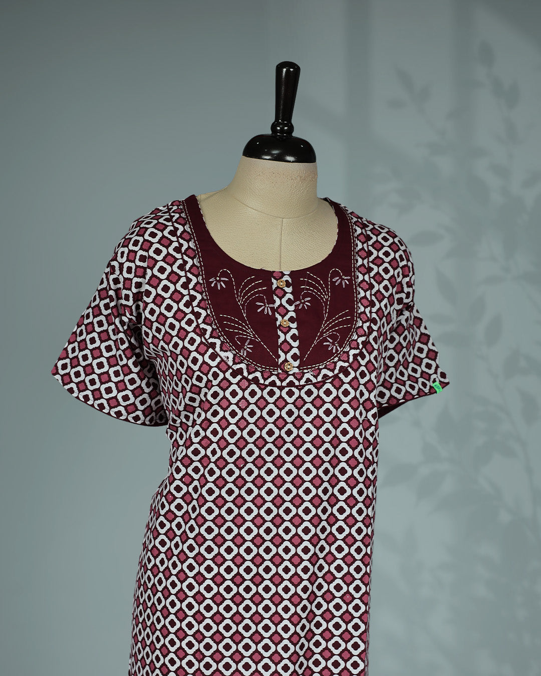 Maroon & White printed nighty featuring an elegant round neckline with embroidered yoke and decorative button detailing, short flutter sleeves and a relaxed full-length fit
