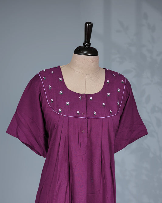 Dark Plum solid nighty featuring a floral embroidered yoke with contrast piping, a round neckline & short sleeves and a relaxed full-length for all-day comfort and timeless style.