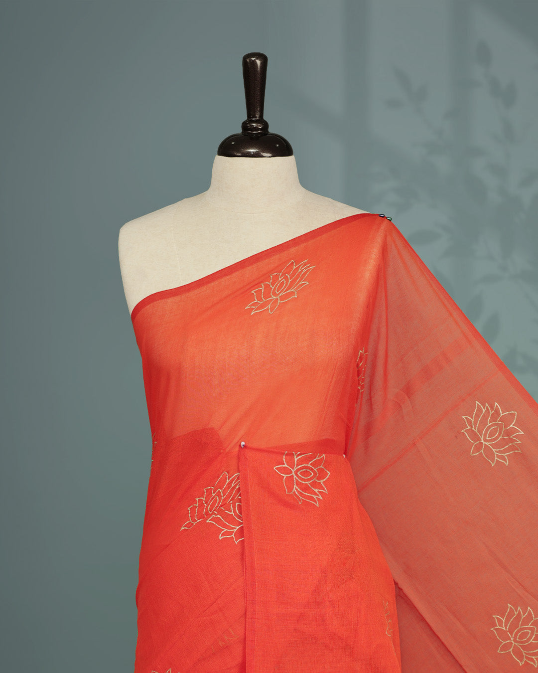 Orange colour pure mul cotton saree featuring Minimal Lotus Print on body, Clean Borderless design, elegant tassels.