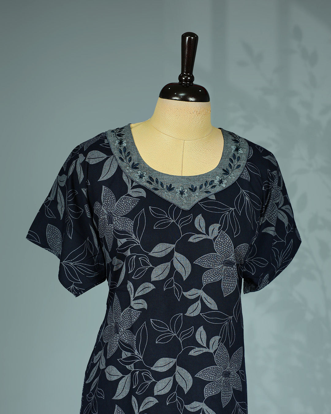 Elegant black floral kodi printed nighty featuring a round neckline with embroidered contrast yoke ,short sleeves and a relaxed full-length for effortless comfort and graceful everyday wear.