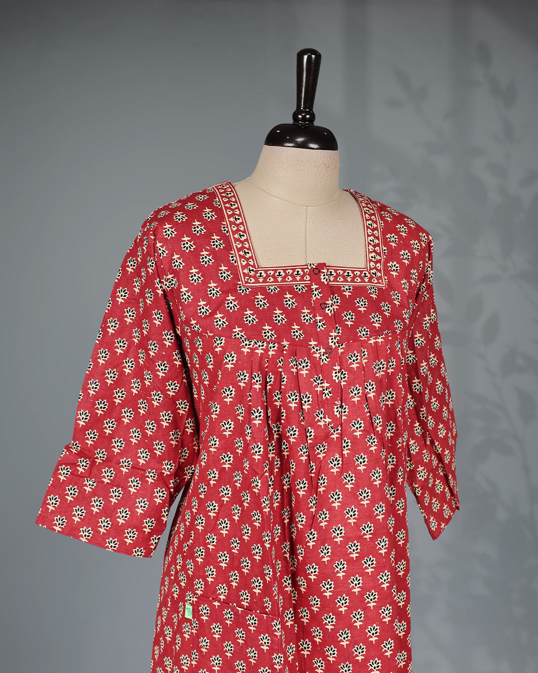Brick Red colour nighty adorned with cream floral prints, featuring an openable button-front square neckline, three-quarter sleeves, and an ankle-length fit