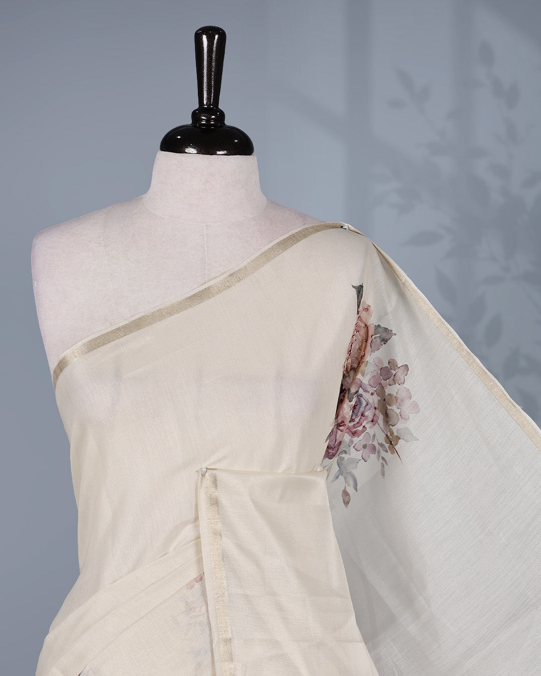Cream colour organza saree featuring floral digital print with sequins With thread buttas on print, complemented by simple gold kasavu kara & elegant tassels on pallu.