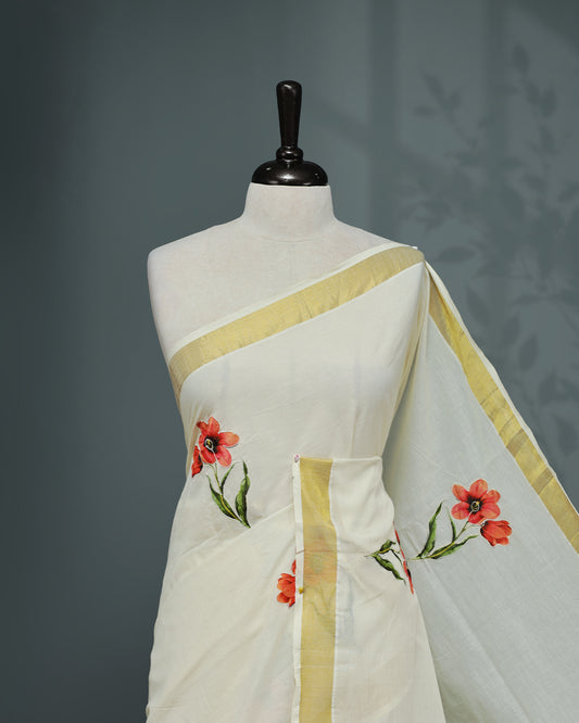 Cream colour Cotton kerala saree featuring floral Print with thread work on the body, complemented by a gold zari Border, paired with a matching blouse piece.