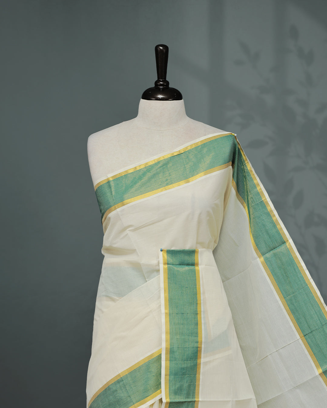 Cream colour Kerala saree Featuring an Elegant plain body, complemented by a classic gold & Green zari border, matching blouse piece.