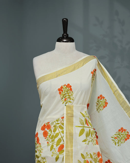 Cream colour Cotton kerala saree featuring Orange colour floral Print on the body, complemented by a gold zari Border, paired with a matching blouse piece.