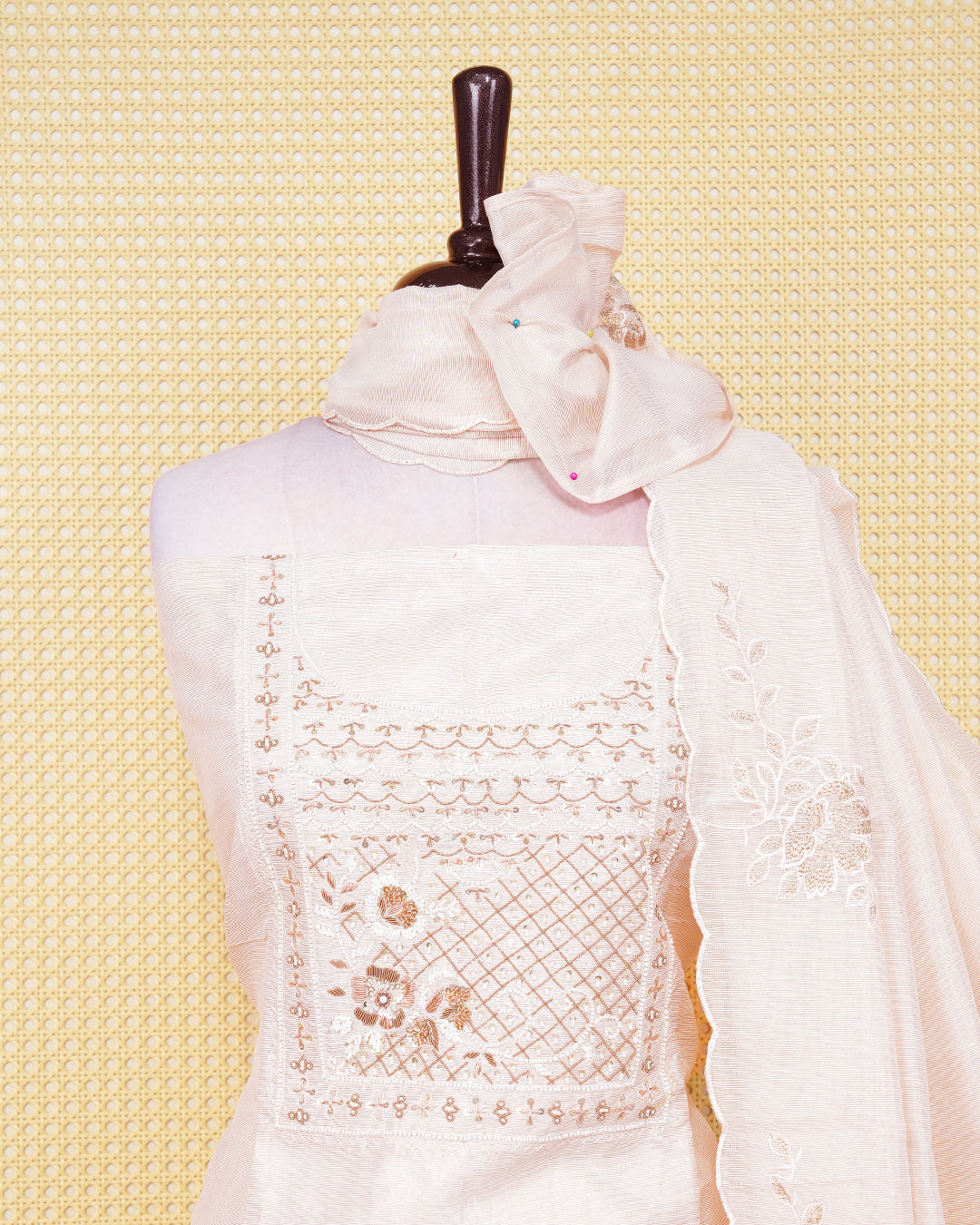 Cream  colour tissue salwar material featuring an elegant floral pattern on body, beadwork on chest portion, paired with a matching bottom and an elegant dupatta.