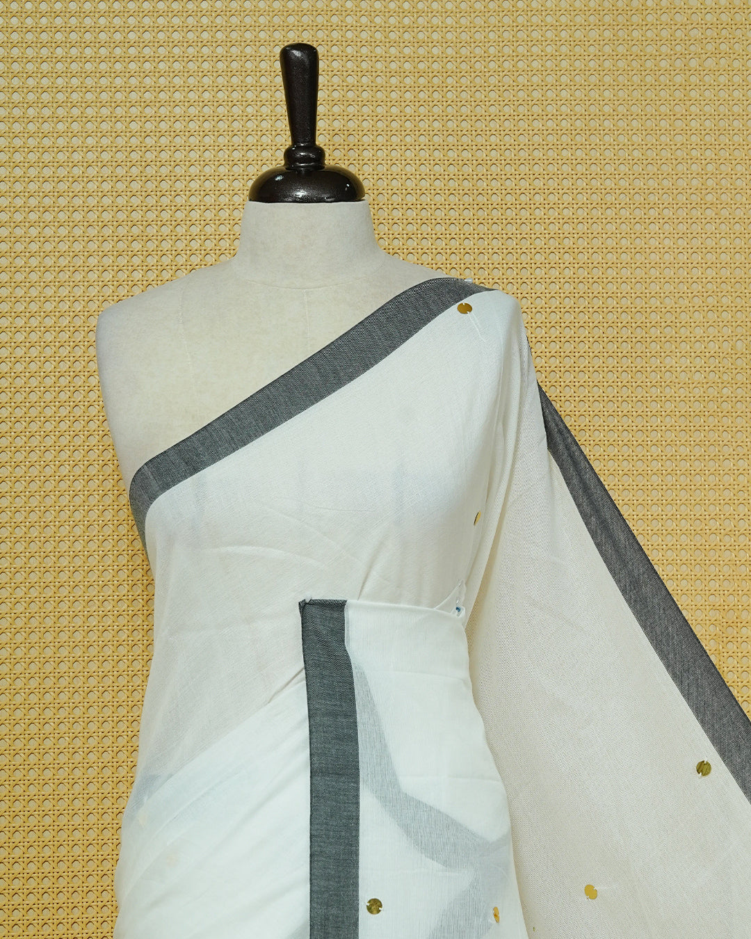 White colour Mul cotton saree featuring Gold Sequins, complemented by Contrast Black simple Border & tassels.