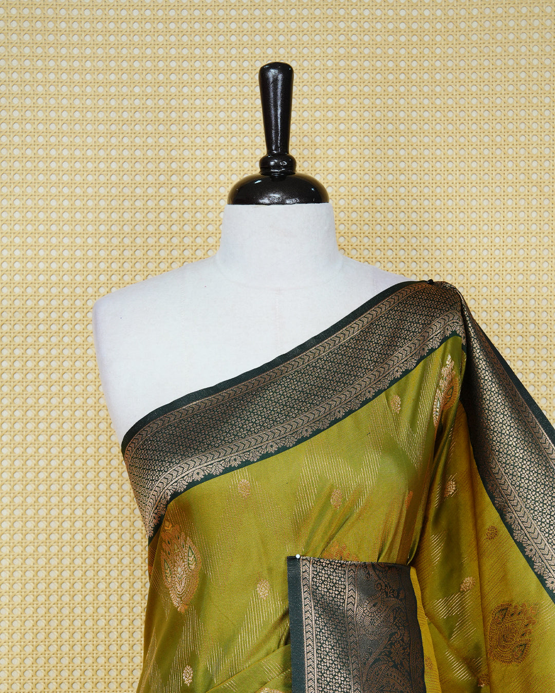 Olive colour Mulberry silk saree featuring floral gold zari patterns on body, paired with contrast bottle green colour with traditional border, comes with matching blouse piece.