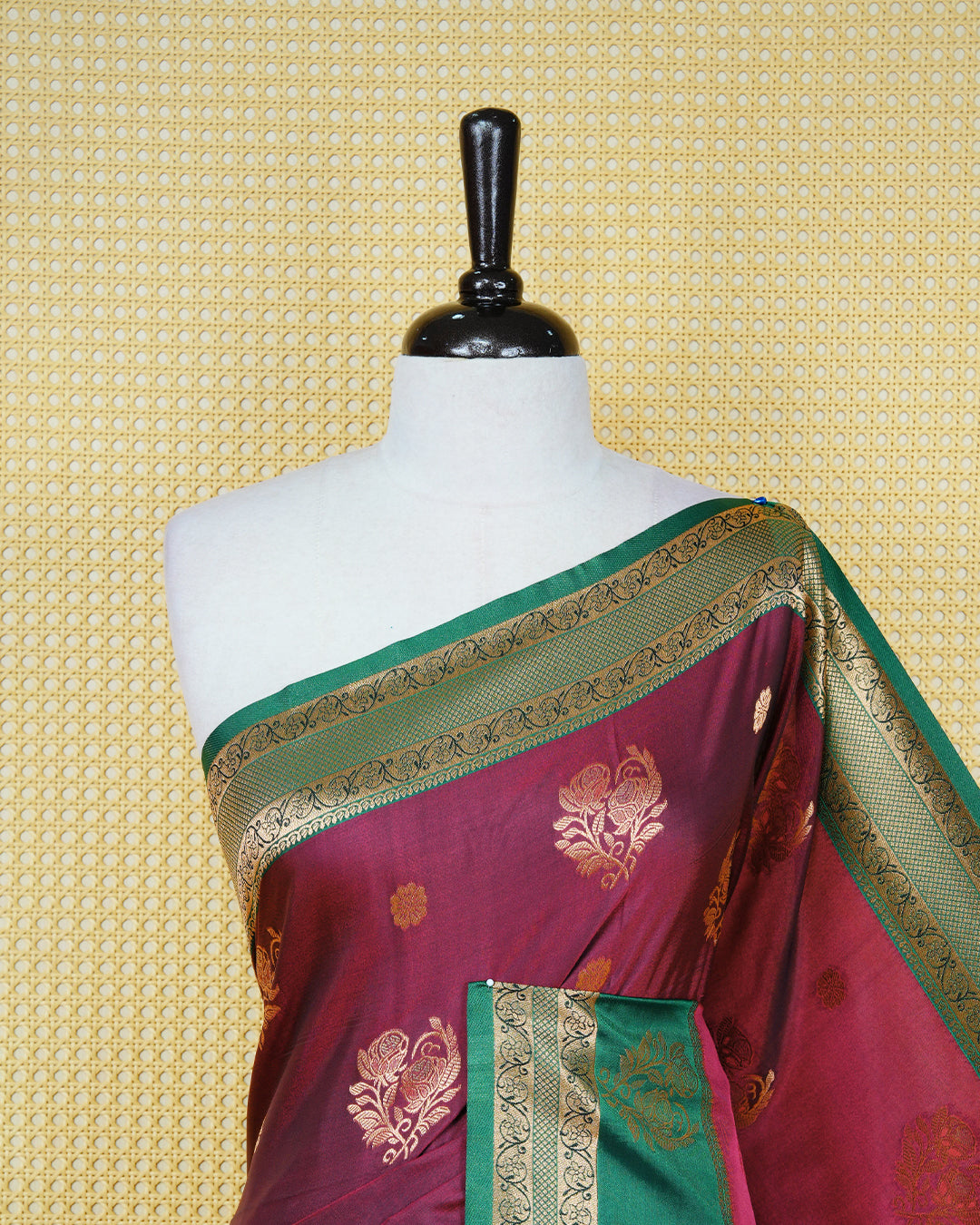 Maroon colour Mulberry silk saree featuring gold floral zari patterns on body, paired with contrast green colour with traditional border, comes with matching blouse piece.