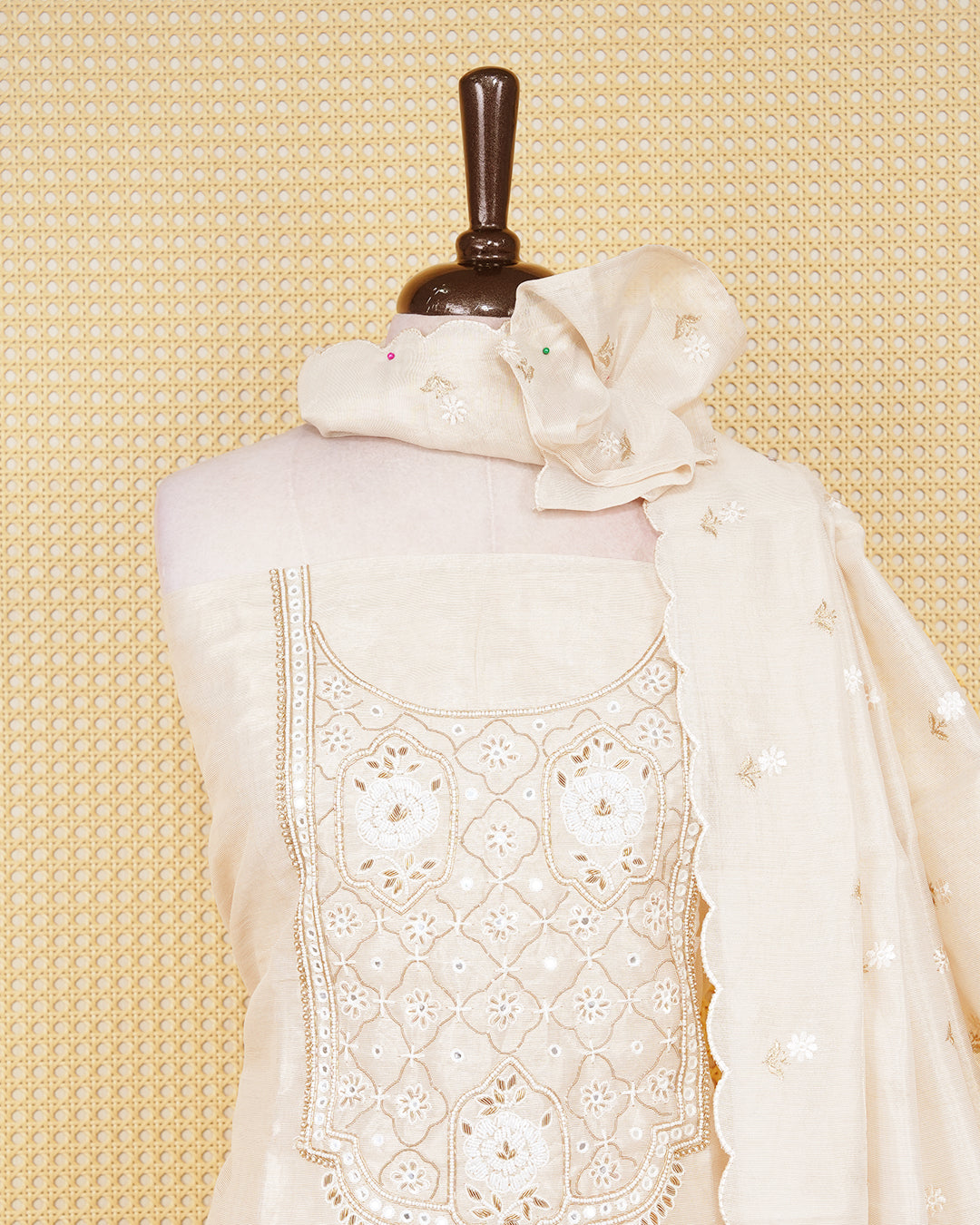 Cream colour tissue salwar material featuring elegant floral embroidery pattern adorned with Mirror and beadswork on Top, paired with matching bottom and elegant dupatta.