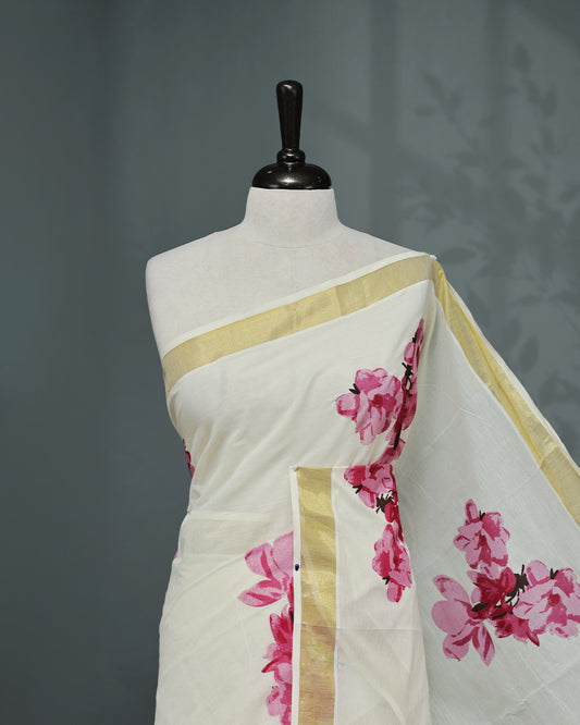 Cream colour Cotton kerala saree featuring Magenta colour floral Print on the body, complemented by a gold zari Border, paired with a matching blouse piece.