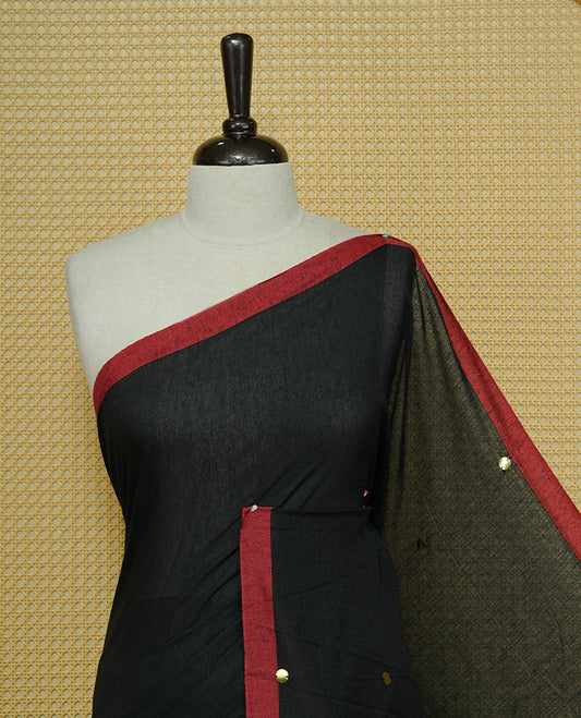Black colour Mul cotton saree featuring Gold Sequins, complemented by Contrast Red simple Border & tassels.