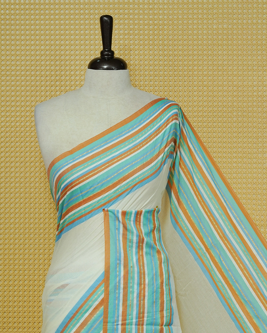 Cream colour Mul cotton saree featuring Elegant Plain body, complemented by contrast Aqua, Blue, Brown & gold zari border & Tassels.