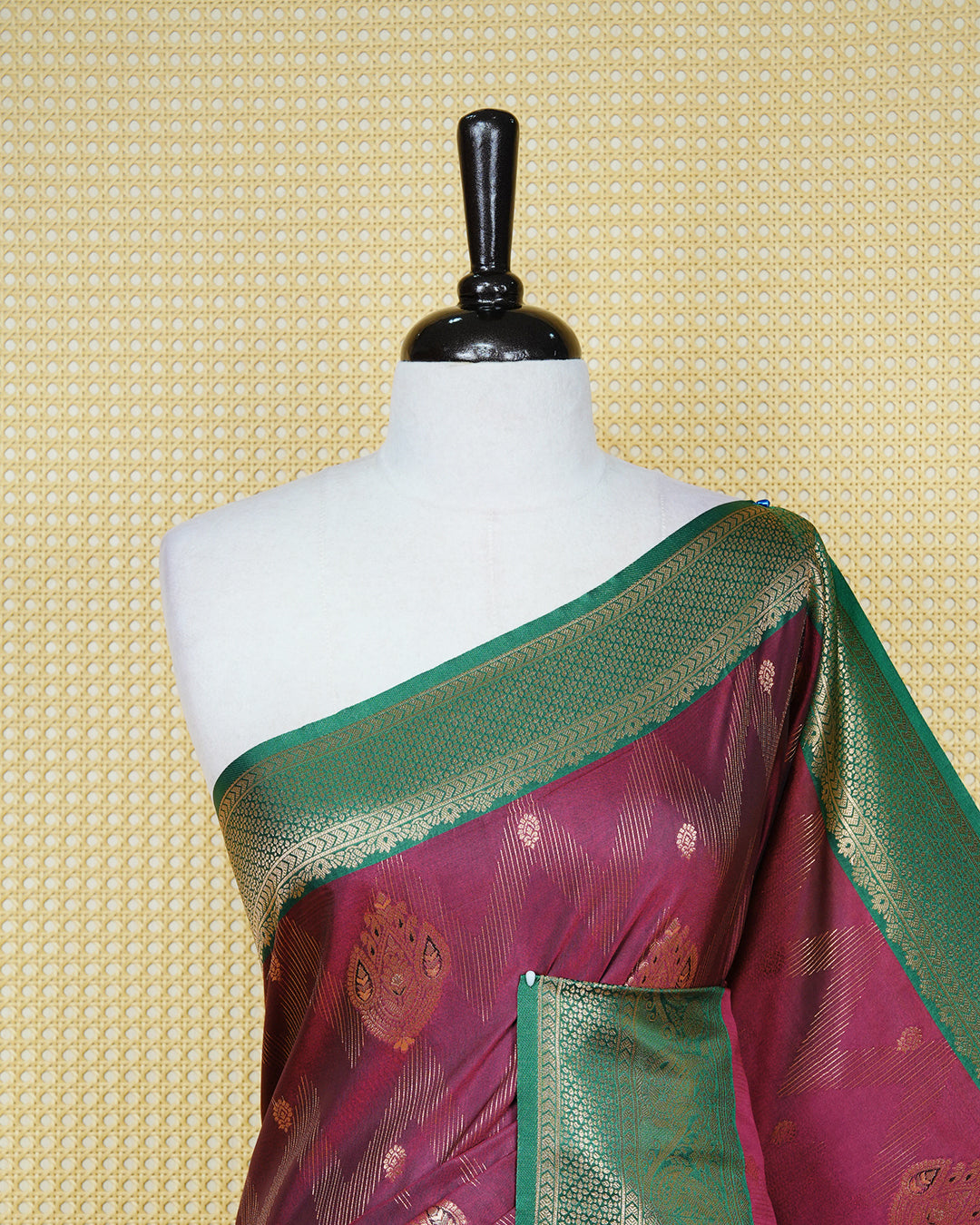 Maroon colour Mulberry silk saree featuring gold floral zari patterns on body, paired with contrast green colour with traditional border, comes with matching blouse piece.