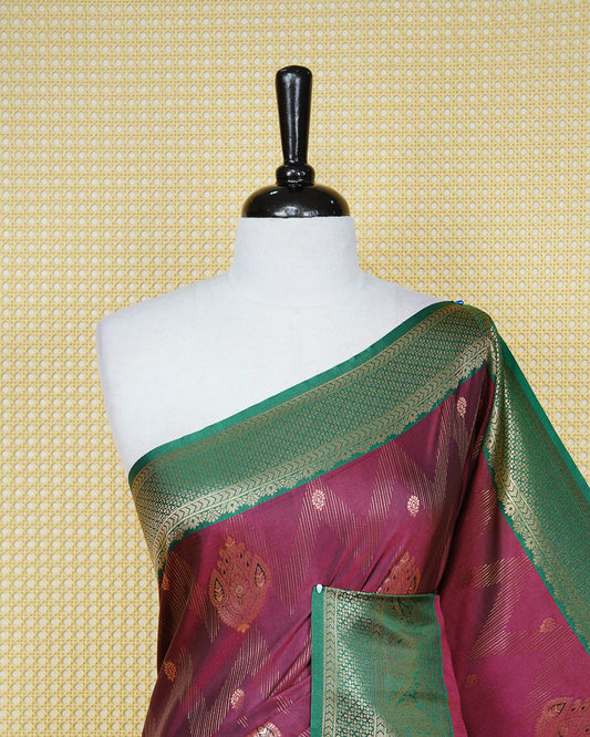 Maroon colour Mulberry silk saree featuring gold floral zari patterns on body, paired with contrast green colour with traditional border, comes with matching blouse piece.
