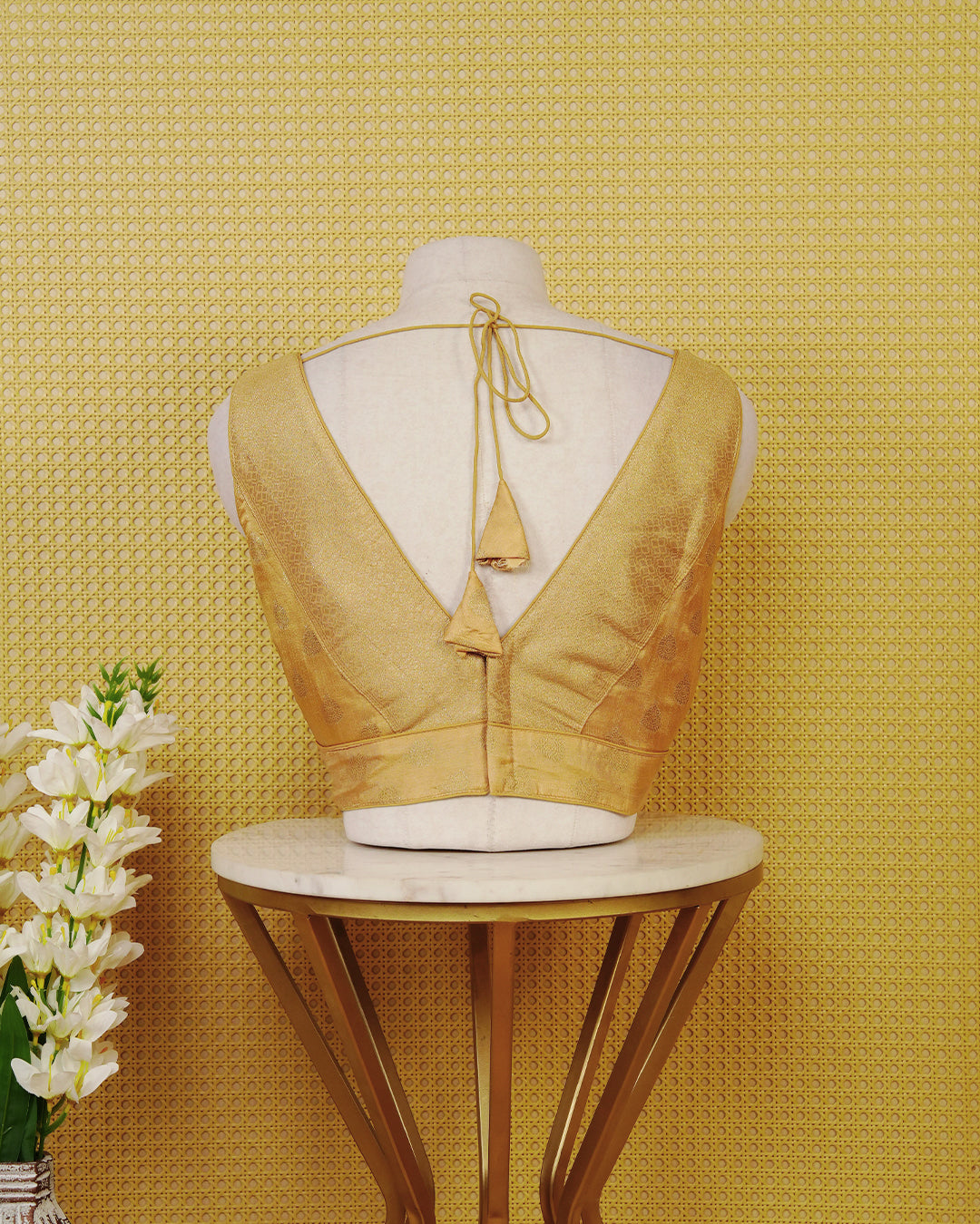 Gold colour Sleeveless Blouse Featuring A Stylish V-Neck, Elegant Woven Pattern With Gold Butta Motifs, And A Comfortable Tailored Fit.