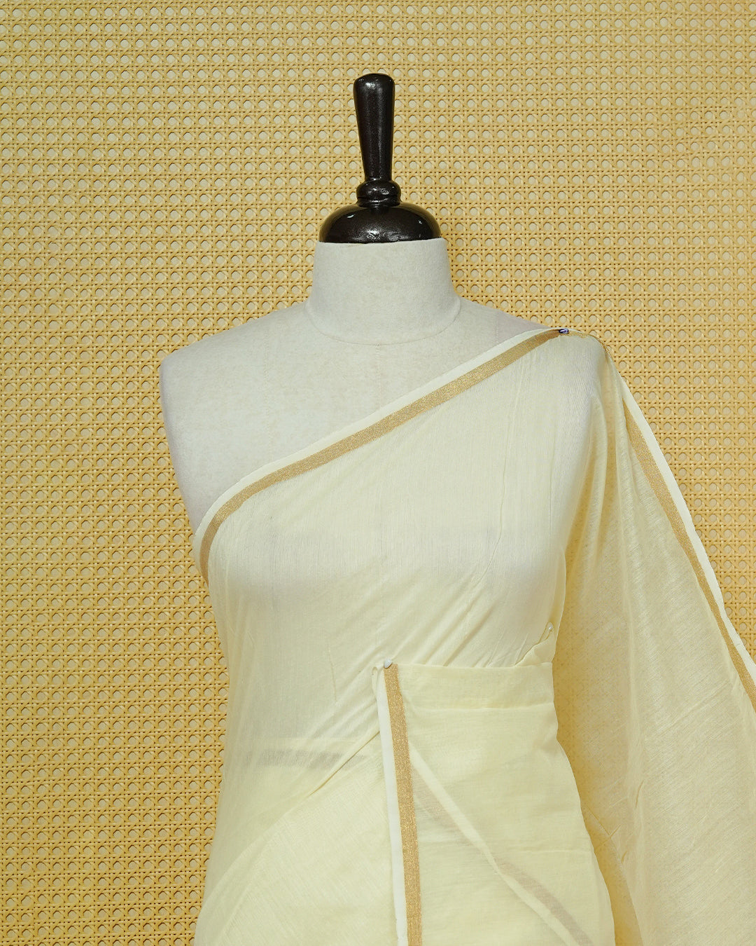 Cream Mul Cotton Saree featuring an elegant plain body, complemented by a subtle gold zari border and sky blue tassels.