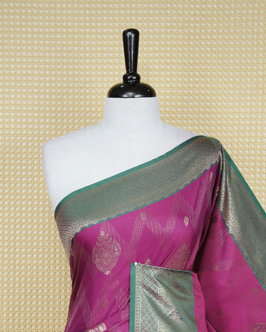 Magenta colour Mulberry silk saree featuring gold floral zari patterns on body, paired with contrast green colour with traditional border, comes with matching blouse piece.