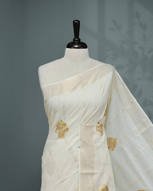 Cream colour Cotton kerala saree featuring Gold Embroidery strips with motifs on the body, complemented by a gold zari Border, paired with a matching blouse piece.