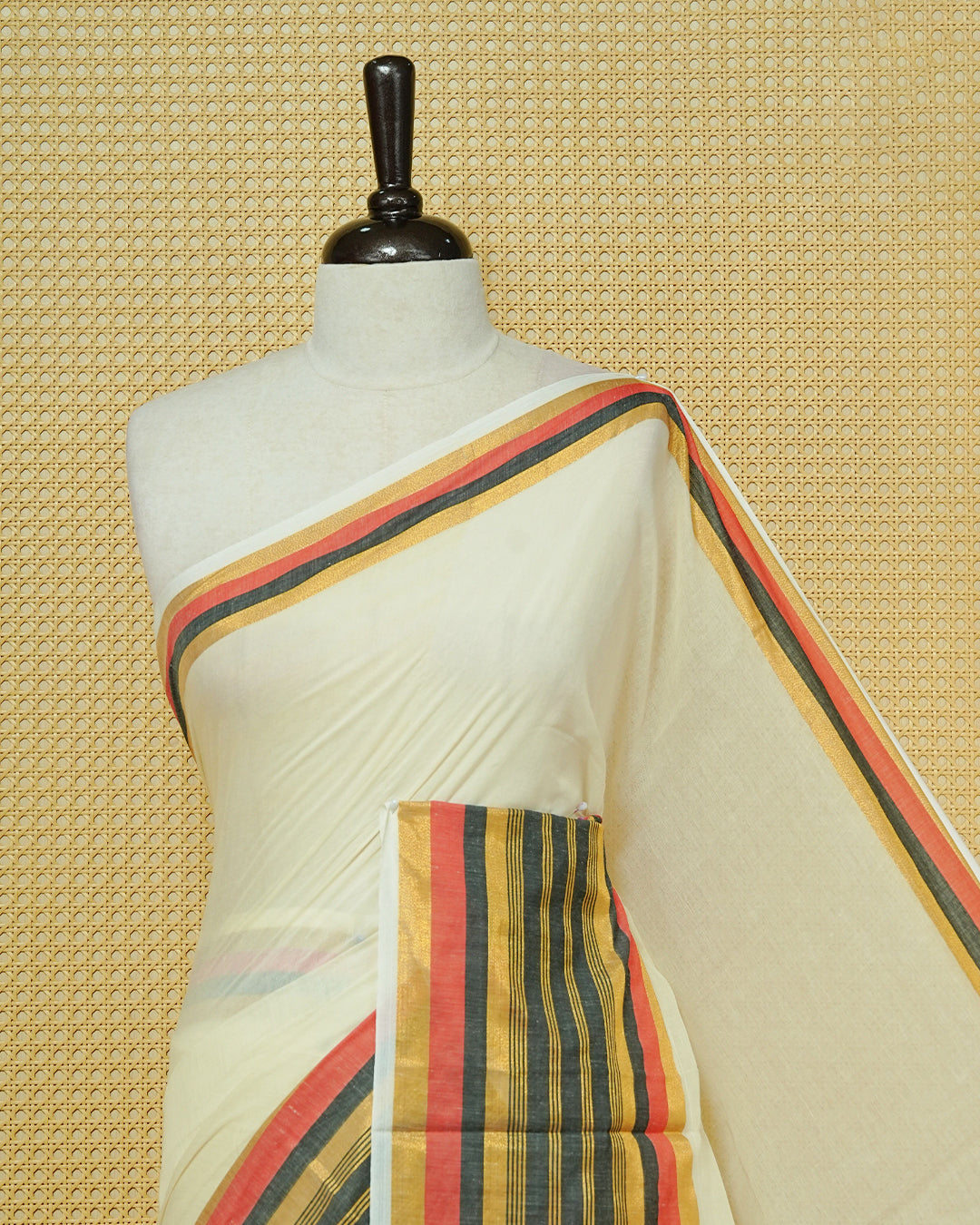 Cream colour Mul cotton saree featuring Elegant Plain body, complemented by contrast Red, Black & gold zari border & Tassels.