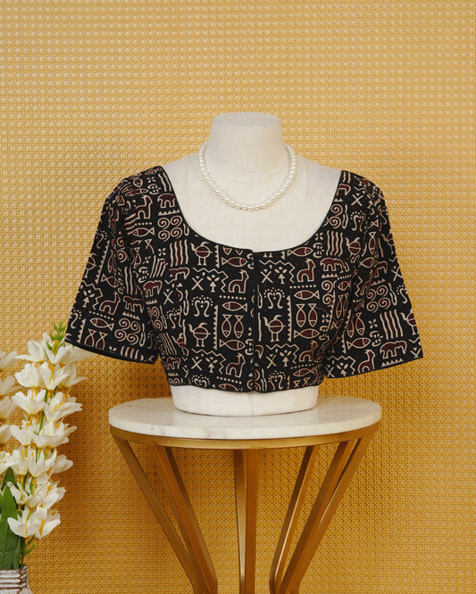 Black Colour Printed Blouse Featuring An All Over Tribal Inspired Geometric Motif Pattern, Enhanced With A Round Neckline, Front Button Closure, And Short Sleeves.